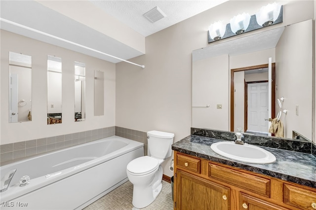 full bathroom featuring visible vents, toilet, a textured ceiling, vanity, and a bath