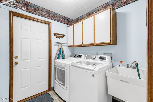 laundry room with cabinet space, light tile patterned floors, independent washer and dryer, a textured ceiling, and a sink