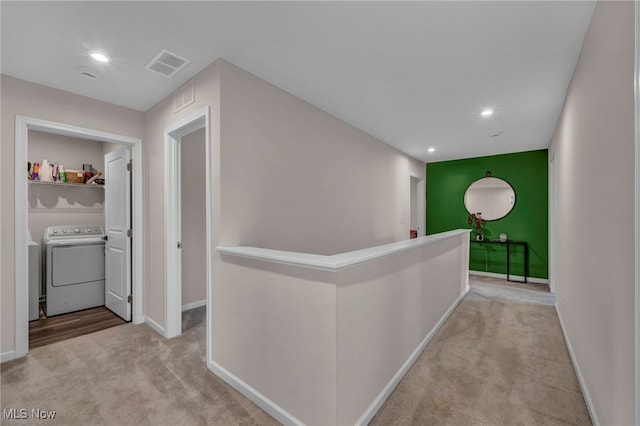 hallway featuring baseboards, visible vents, carpet flooring, and an upstairs landing