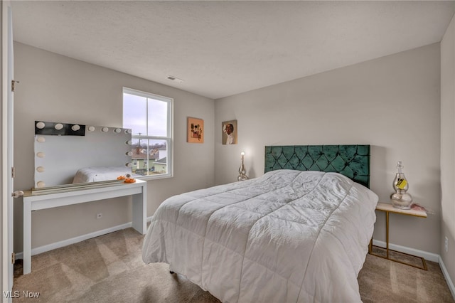 carpeted bedroom with visible vents and baseboards