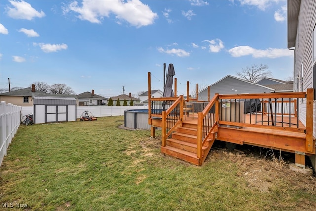 view of yard featuring a storage shed, a fenced backyard, a wooden deck, and an outdoor structure