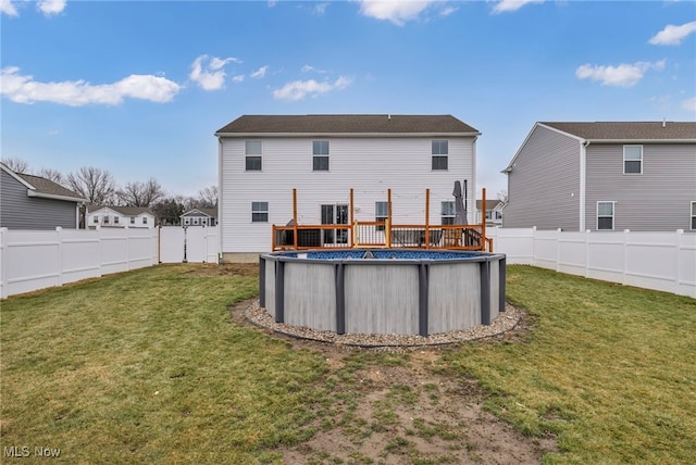 back of property with a fenced in pool, a fenced backyard, and a yard