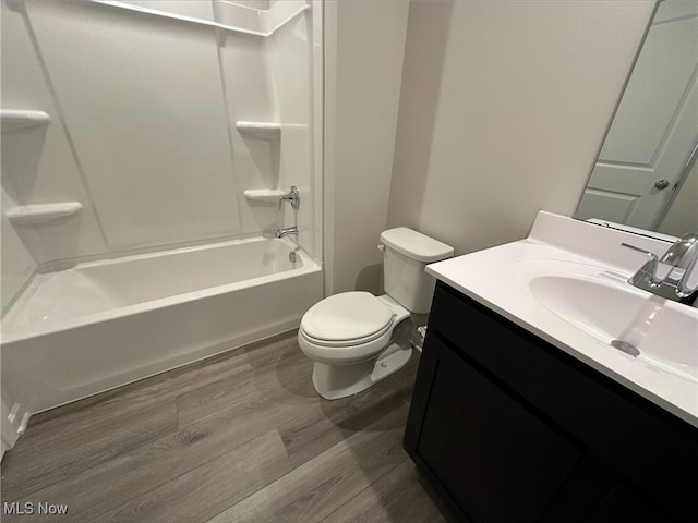 bathroom featuring shower / bathtub combination, vanity, toilet, and wood finished floors