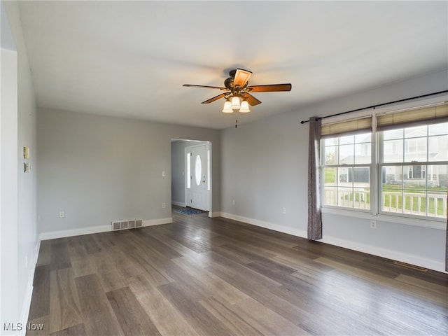 empty room featuring baseboards, visible vents, ceiling fan, and wood finished floors