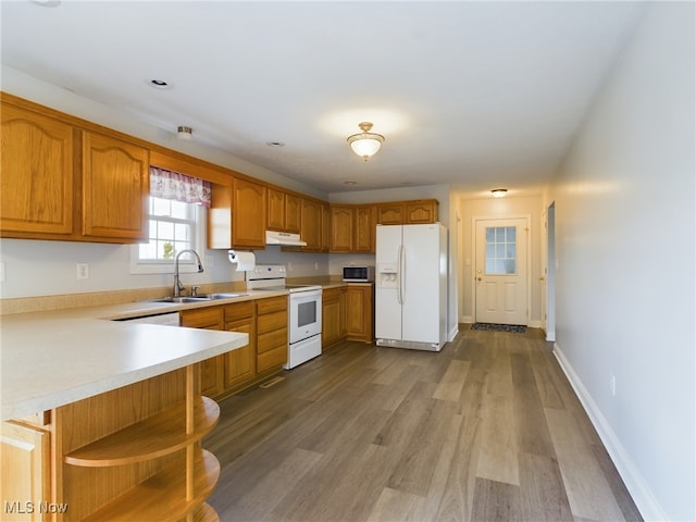 kitchen with under cabinet range hood, white appliances, a sink, brown cabinets, and open shelves