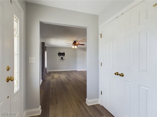 corridor with dark wood-style floors and baseboards