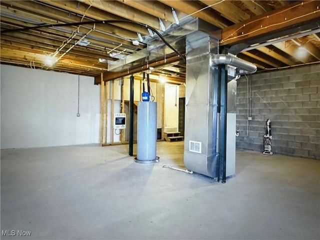 unfinished basement with water heater and heating unit