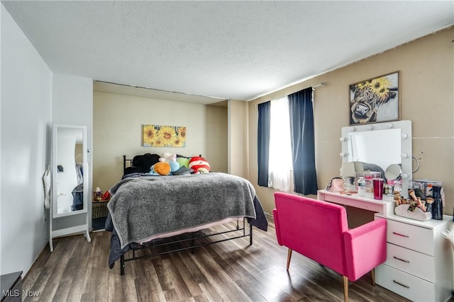 bedroom with a textured ceiling and wood finished floors