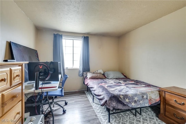 bedroom featuring a textured ceiling and wood finished floors