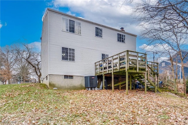 rear view of property with stairs, a chimney, and a deck