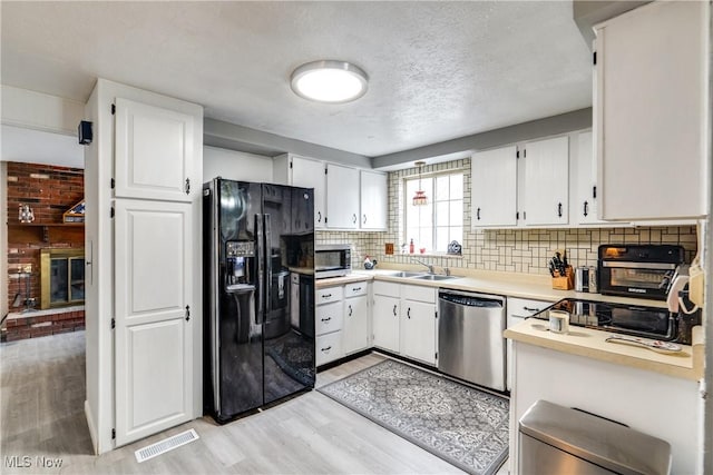 kitchen featuring visible vents, stainless steel appliances, a sink, and light countertops