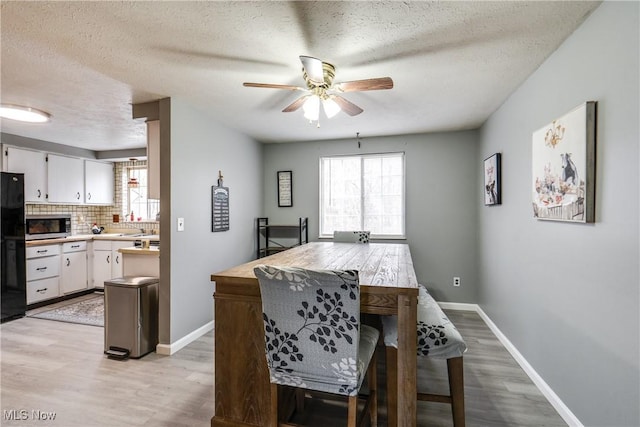 dining area with light wood-type flooring, plenty of natural light, and baseboards