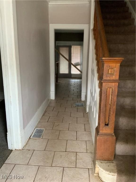 hall featuring stairway, visible vents, and baseboards