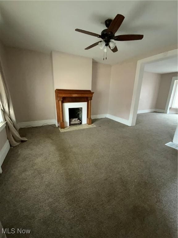 unfurnished living room featuring a fireplace with flush hearth, carpet, and baseboards