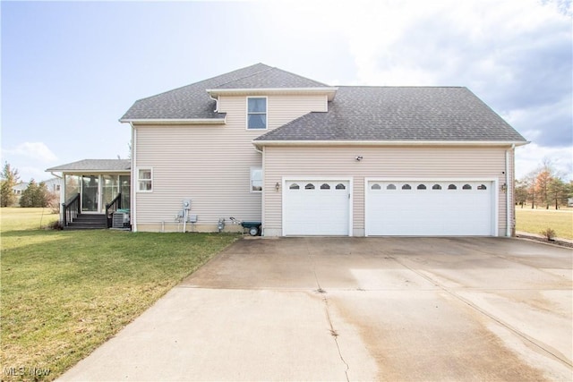 exterior space featuring roof with shingles, concrete driveway, a sunroom, a garage, and a front lawn