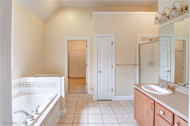 full bath with lofted ceiling, a tub with jets, tile patterned flooring, vanity, and a closet