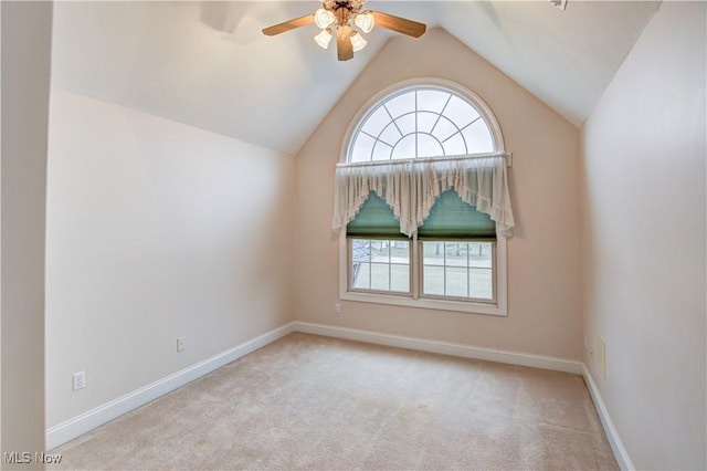 carpeted empty room featuring vaulted ceiling, a ceiling fan, and baseboards