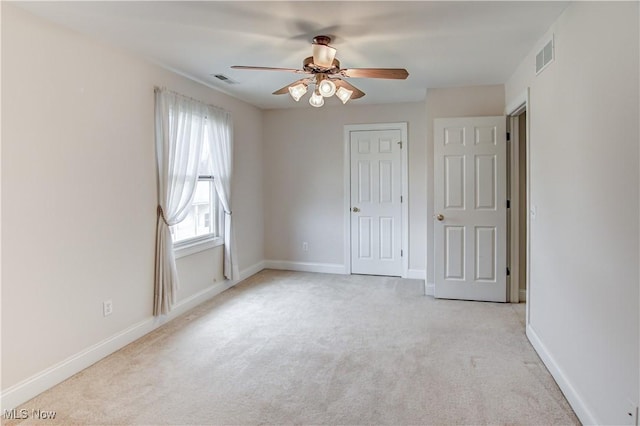 unfurnished bedroom featuring baseboards, visible vents, and light colored carpet