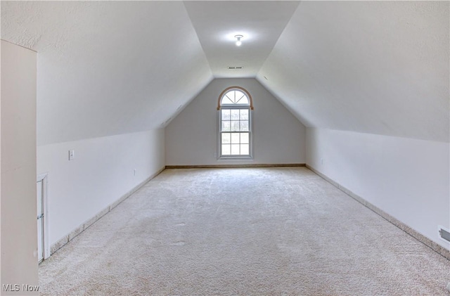 bonus room with vaulted ceiling, carpet flooring, visible vents, and baseboards