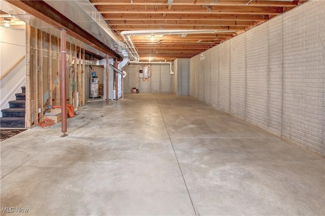 unfinished basement featuring gas water heater, brick wall, and stairs