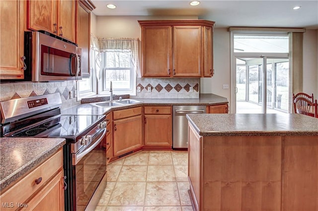 kitchen featuring stainless steel appliances, dark countertops, a sink, and backsplash