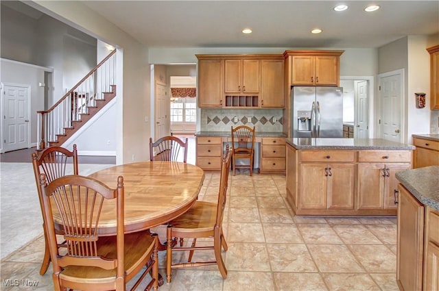 kitchen with stainless steel fridge with ice dispenser, a center island, open shelves, backsplash, and recessed lighting