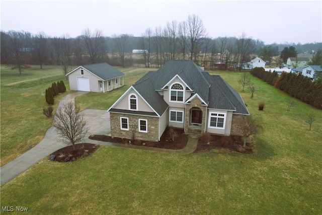 view of front of house featuring a garage, driveway, a front lawn, and stone siding