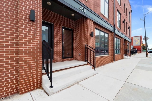 doorway to property featuring brick siding