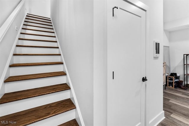 stairs featuring wood finished floors