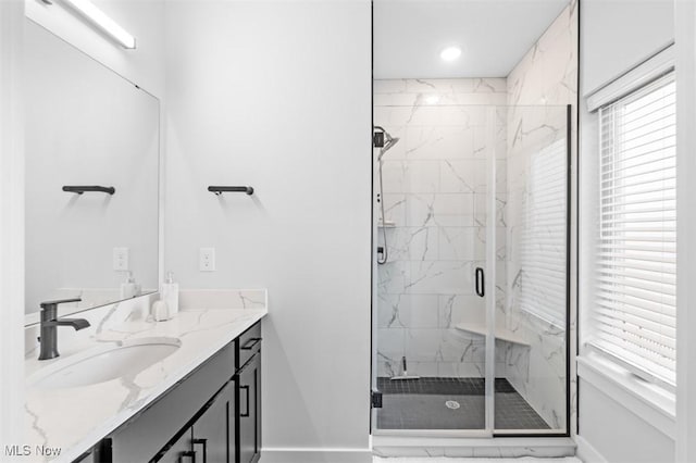 bathroom with recessed lighting, a marble finish shower, vanity, and baseboards