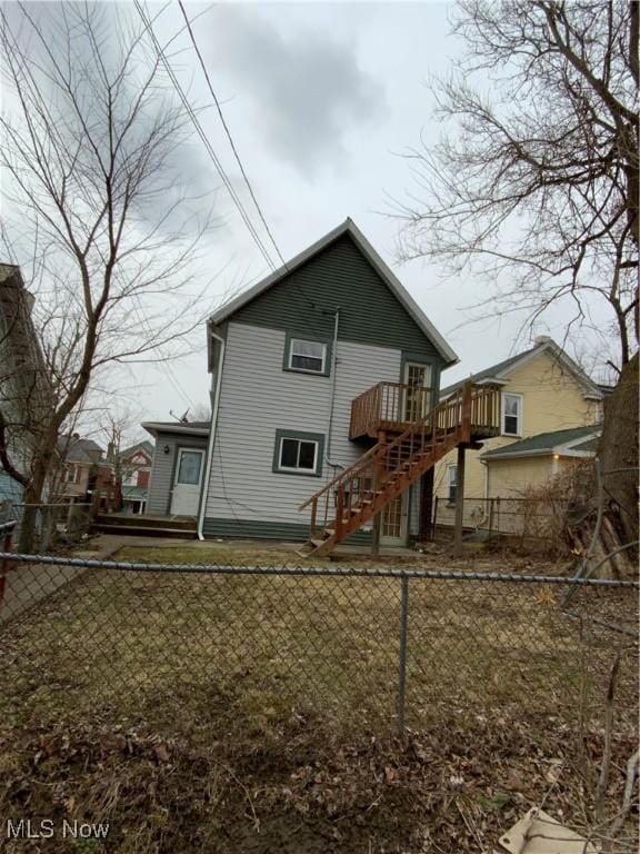 rear view of property with a fenced backyard, stairway, and a wooden deck