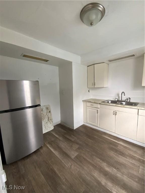 406 Vine St, East Liverpool, OH 43920 - kitchen with dark wood-style floors, freestanding refrigerator, white cabinetry, and a sink