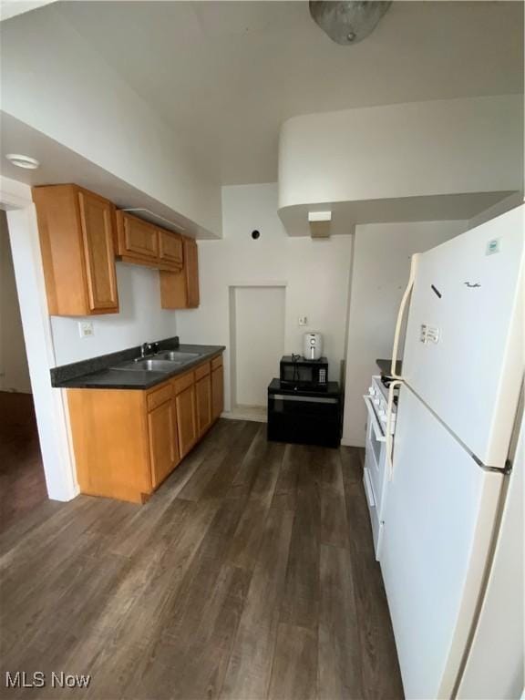 406 Vine St, East Liverpool, OH 43920 - kitchen with dark wood finished floors, dark countertops, brown cabinetry, a sink, and white appliances