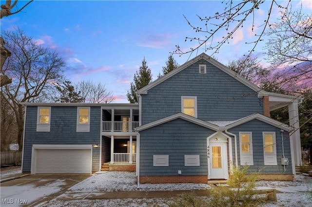 view of front of house with a balcony, a garage, and concrete driveway