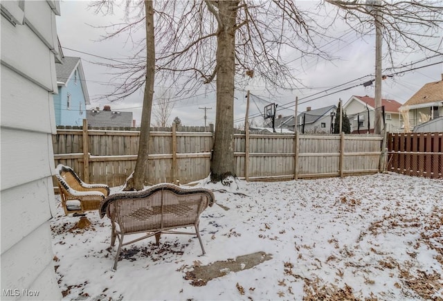 yard covered in snow with a fenced backyard