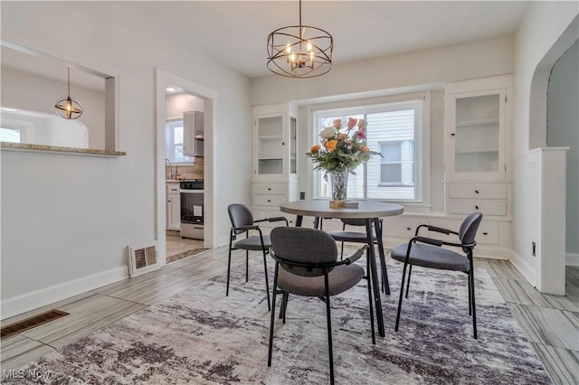 dining space featuring light wood-type flooring, baseboards, and visible vents