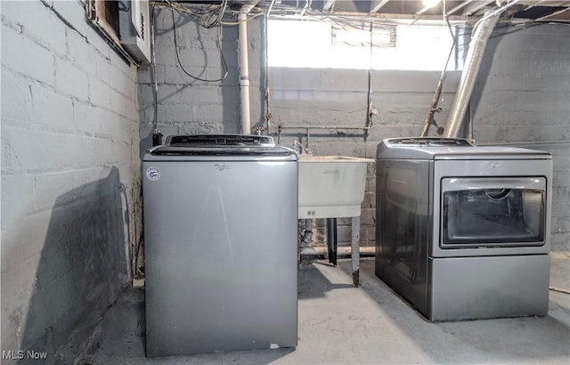 laundry area with laundry area, a sink, and washer and clothes dryer