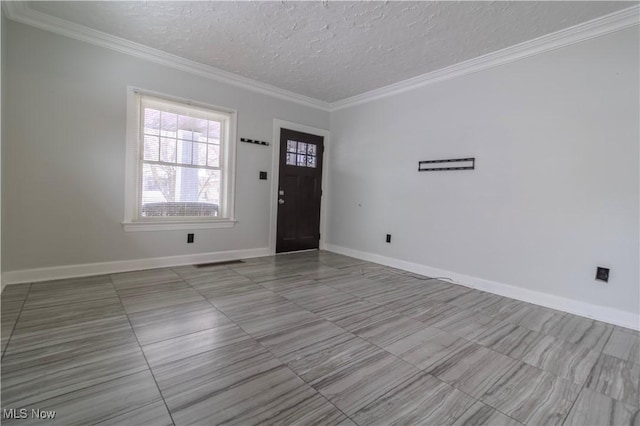 foyer with a textured ceiling, baseboards, and crown molding