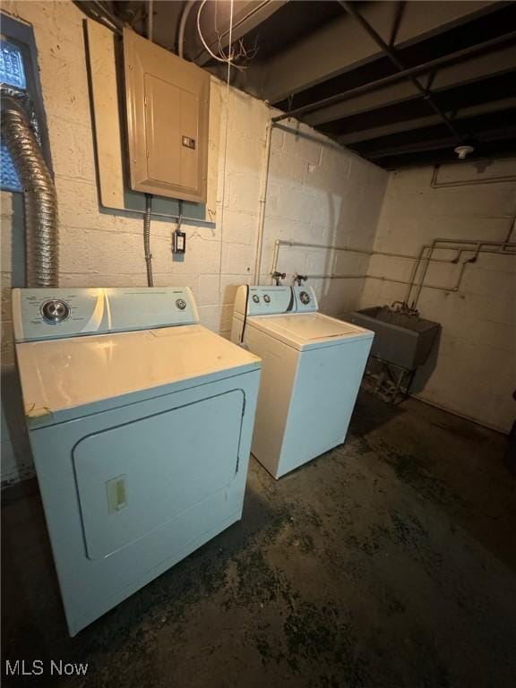 laundry room with laundry area, electric panel, washer and clothes dryer, and a sink