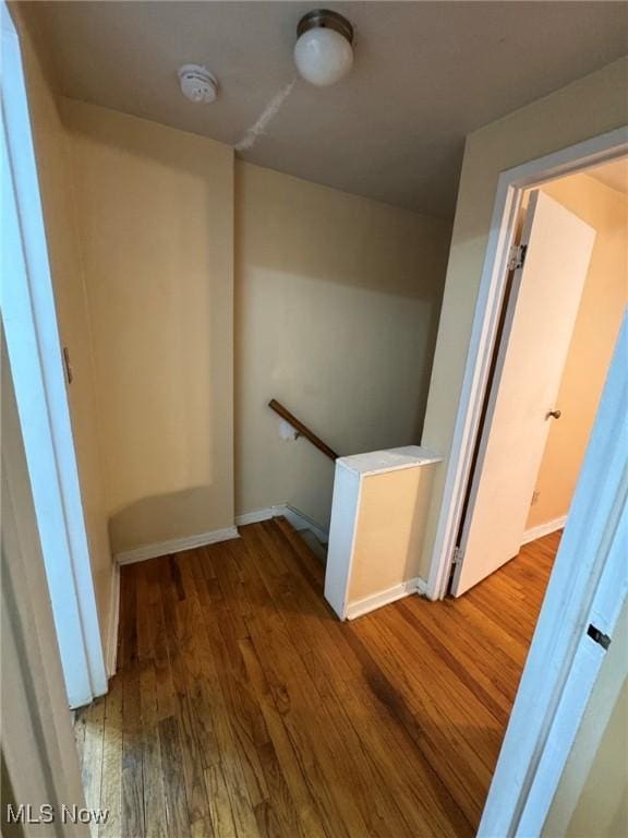 stairway with baseboards and wood finished floors