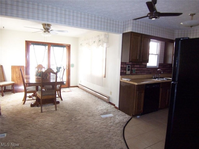 kitchen featuring light colored carpet, a baseboard heating unit, a sink, ceiling fan, and black appliances