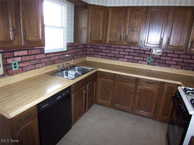 kitchen featuring range with gas stovetop, light countertops, dishwasher, and a sink