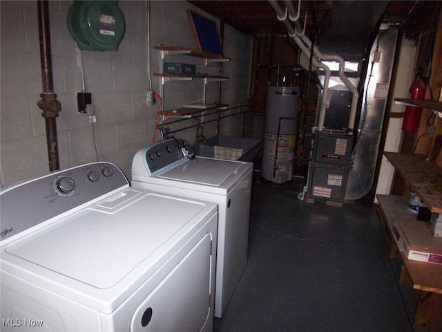 washroom featuring concrete block wall, gas water heater, washer and clothes dryer, heating unit, and laundry area