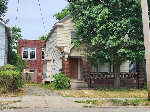 view of front facade with a porch and brick siding