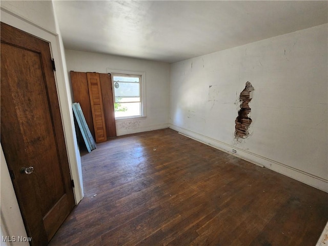 unfurnished room with baseboards and wood finished floors