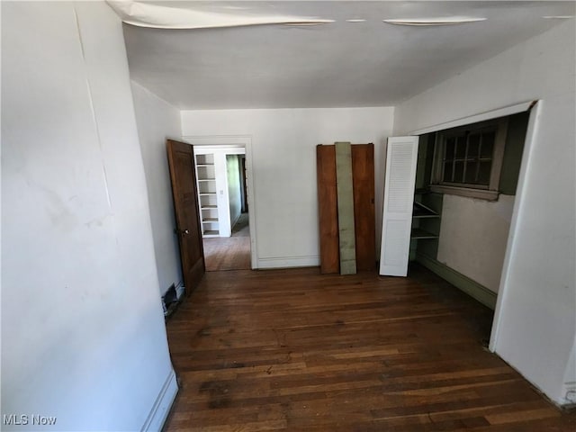 hall featuring baseboards and wood finished floors