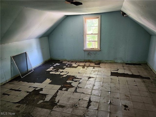 additional living space with lofted ceiling and tile patterned floors