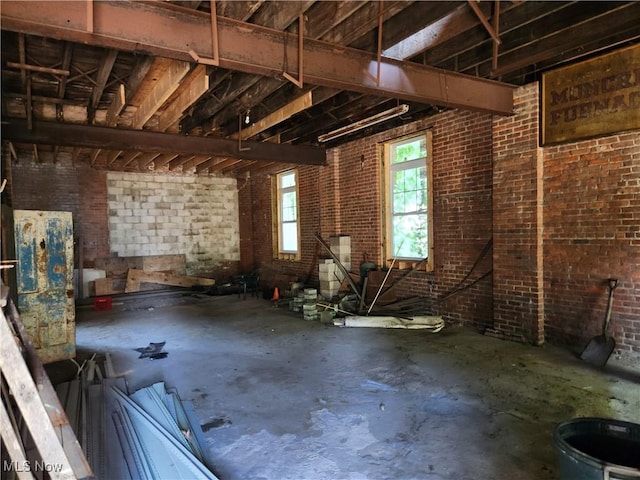 miscellaneous room featuring concrete flooring and brick wall