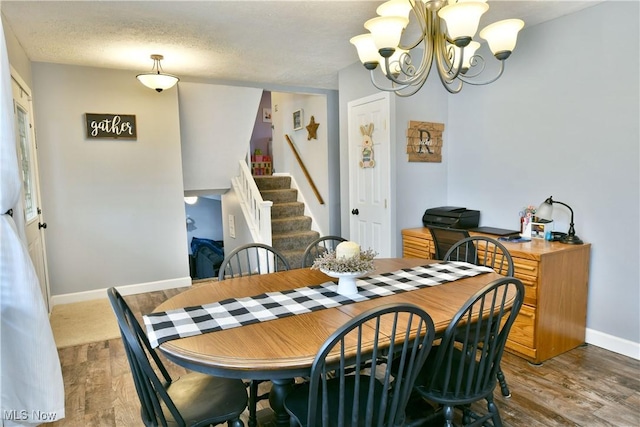 dining area featuring baseboards, stairway, a chandelier, and wood finished floors