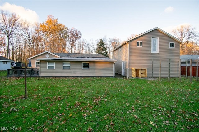 back of house with fence and a yard